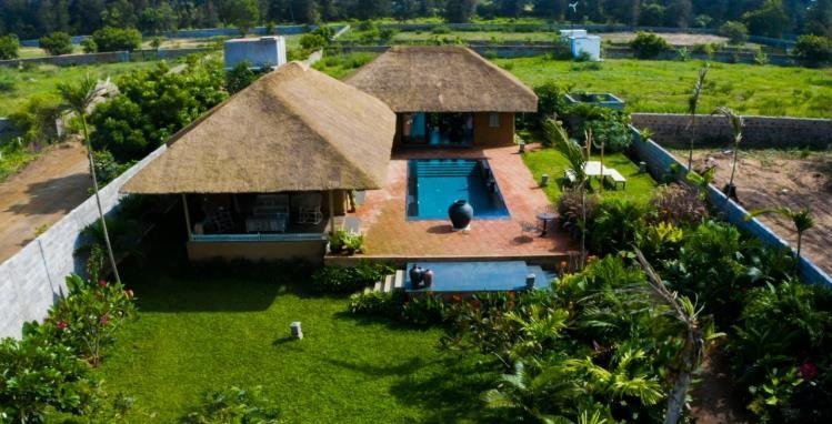 Completed thatched mud-house cottage project with a landscaped courtyard and pool